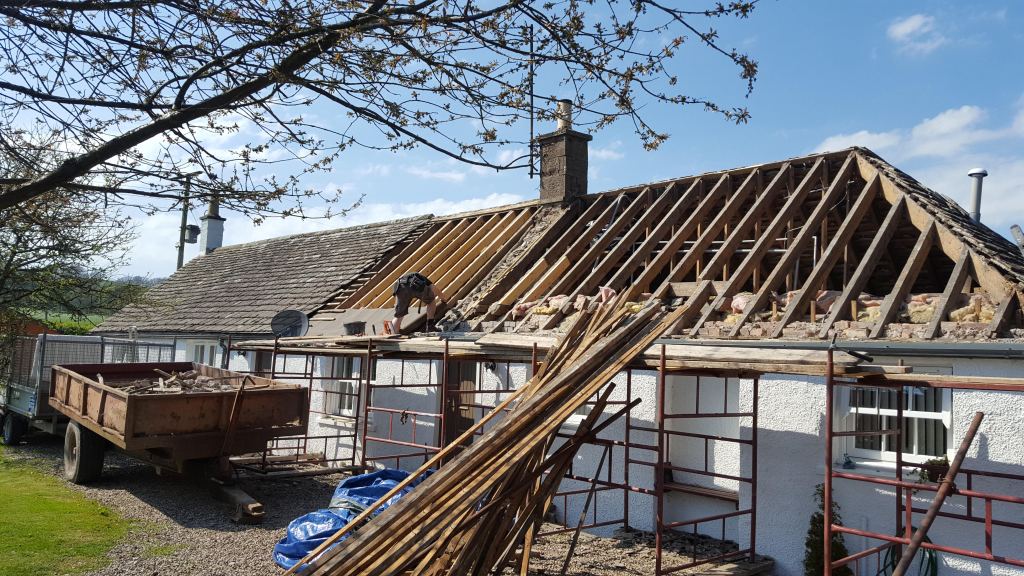 A photo of a cottage roof being stripped